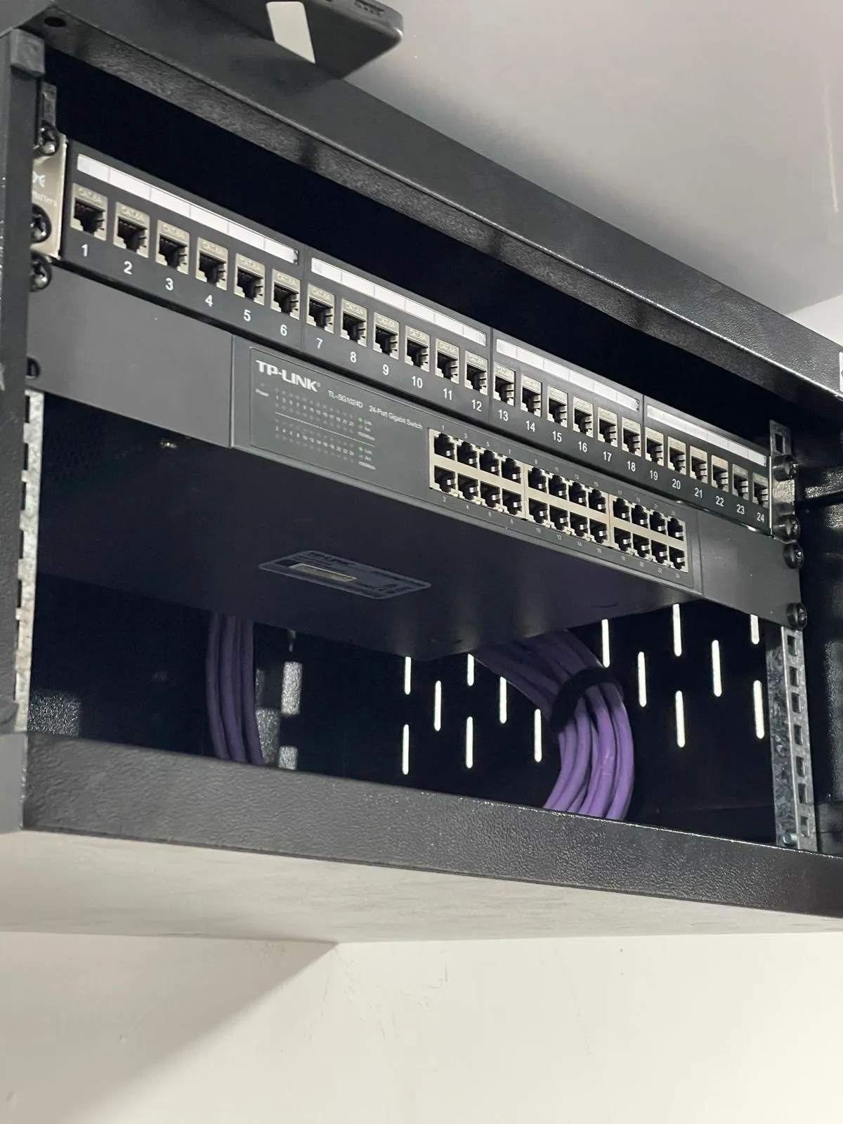 Rack con switch de 24 puertos: Gabinete de pared con patch panel y switch gigabit. Trabajo de Elite Tech en el Caquetá.